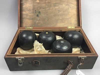 Lot 215 - A SET OF FOUR LAWN BOWLS IN A WOOD CARRY CASE