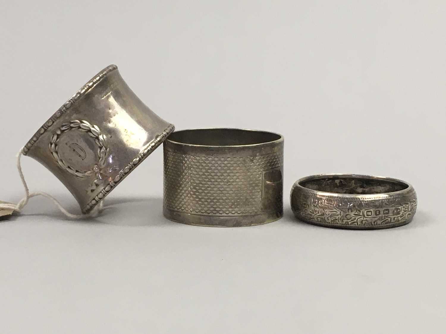 Lot 365 - A SILVER NAPKIN RING AND TWO OTHER TWO NAPKIN RINGS