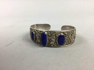 Lot 428 - A CHINESE EMBOSSED BANGLE WITH LAPIS LAZULI CABOCHONS