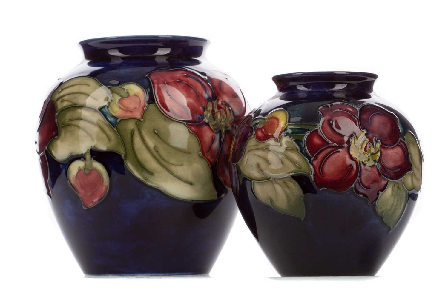 Lot 760 - A GRADUATED PAIR OF MOORCROFT 'ANEMONE' PATTERN VASES