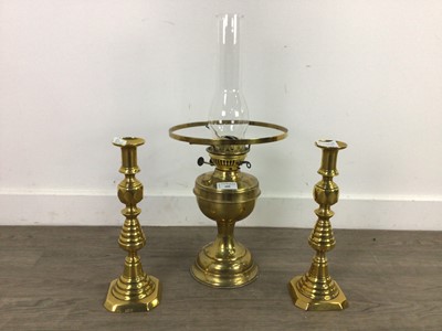 Lot 488 - A BRASS OIL LAMP AND A PAIR OF CANDLESTICKS