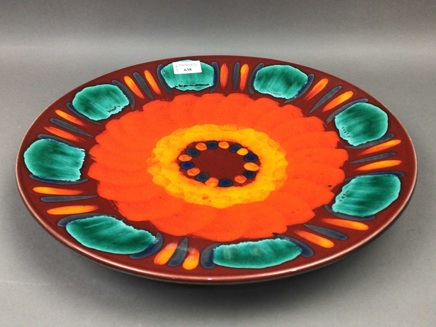 Lot 638 - A POOLE POTTERY VOLCANO RANGE CHARGER
