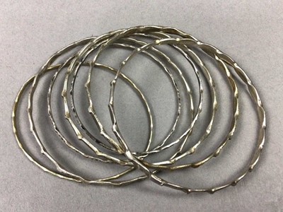 Lot 593 - ELEVEN SILVER AND WHITE METAL BANGLES