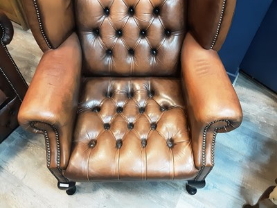 Lot 611 - DARK TAN LEATHER  WINGBACK ARMCHAIR