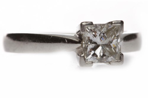 Lot 48 - PLATINUM DIAMOND SOLITAIRE RING with a four...