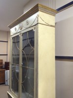 Lot 1445 - CREAM AND GILT PAINTED CABINET BOOKCASE of...