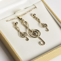 Lot 1682 - NINE CARAT GOLD TREBLE CLEF PENDANT AND...