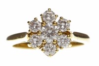 Lot 281 - DIAMOND DAISY CLUSTER RING with a central...