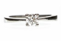 Lot 311 - PLATINUM DIAMOND SOLITAIRE RING with a four...