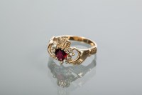 Lot 2167 - NINE CARAT GOLD HEART MOTIF RUBY RING modelled...