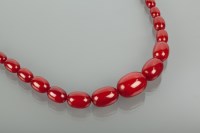 Lot 1150 - RED AMBER BEAD NECKLACE with graduated ovoid...