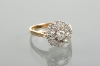 Lot 1236 - DIAMOND CLUSTER RING the central brilliant cut...