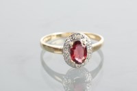 Lot 1276 - GARNET AND DIAMOND RING with a central oval...