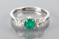 Lot 1761 - EMERALD AND DIAMOND THREE STONE RING with a...