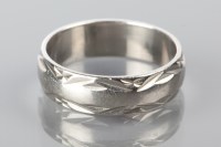 Lot 1766 - PLATINUM WEDDING BAND with engraved decoration,...