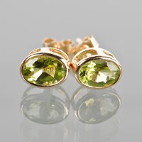 Lot 1757 - PAIR OF PERIDOT STUD EARRINGS each set with an...