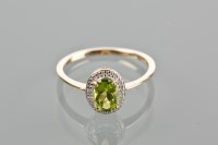 Lot 1758 - PERIDOT RING with a central oval peridot,...