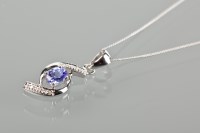 Lot 1766 - TANZANITE AND DIAMOND PENDANT of twist design,...