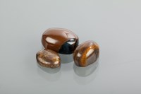 Lot 1841 - THREE UNMOUNTED TIGERS EYE STONES all of oval...