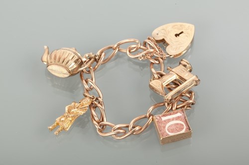 Lot 1700 - NINE CARAT GOLD CHARM BRACELET with charms...