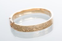 Lot 2007 - NINE CARAT GOLD BANGLE engraved with scrolling...