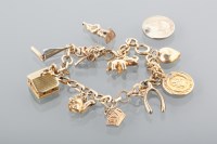 Lot 1632 - TWENTIETH CENTURY GOLD CHARM BRACELET with...