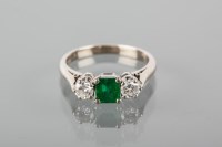 Lot 1726 - EMERALD AND DIAMOND THREE STONE RING with a...