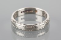 Lot 1728 - PLATINUM WEDDING BAND with engraved decoration,...