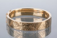 Lot 1751 - NINE CARAT GOLD BANGLE c. 1960s, with engraved...