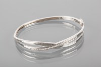 Lot 1768 - WHITE GOLD DIAMOND SET BANGLE with channel set...