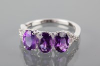 Lot 1783A - AMETHYST DRESS RING set with three oval...