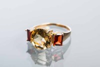 Lot 2204 - CITRINE AND GARNET THREE STONE RING with a...
