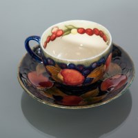 Lot 520 - MOORCROFT CUP AND SAUCER decorated with...