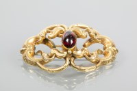 Lot 1737 - VICTORIAN RED GEM SET BROOCH of scrolling form,...