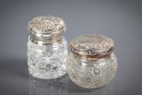 Lot 23 - TWO SILVER LIDDED AND CUT GLASS TOILET JARS...