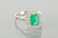 Lot 1126 - EMERALD AND DIAMOND CLUSTER RING with an...