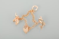 Lot 1241 - NINE CARAT GOLD CHARM BRACELET with three...