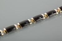 Lot 1384 - BLACK HARDSTONE AND GOLD BRACELET formed by...