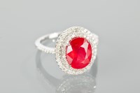 Lot 1386 - RUBY AND DIAMOND RING the central oval ruby of...