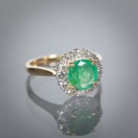 Lot 1114 - EMERALD AND DIAMOND CLUSTER RING with a...