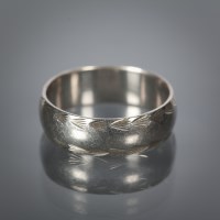 Lot 1120 - PLATINUM WEDDING BAND with engraved decoration,...