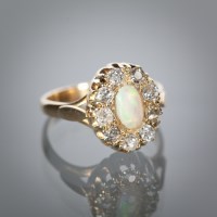 Lot 1134 - OPAL AND DIAMOND CLUSTER RING the central oval...