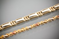 Lot 1213 - TWO NINE CARAT GOLD BRACELETS comprising a tri...