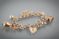 Lot 1245 - NINE CARAT GOLD CHARM BRACELET with charms...