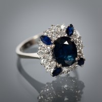 Lot 1354 - SAPPHIRE AND DIAMOND CLUSTER RING set with a...