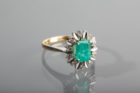 Lot 1135 - EMERALD AND DIAMOND CLUSTER RING with a...