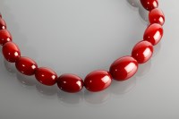 Lot 1161 - RED BAKELITE BEAD NECKLACE with graduated...