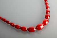 Lot 1165 - GRADUATED BAKELITE NECKLACE the beads of red...