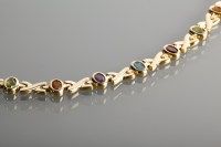 Lot 1228 - GOLD MULTI GEM SET BRACELET with oval stones...