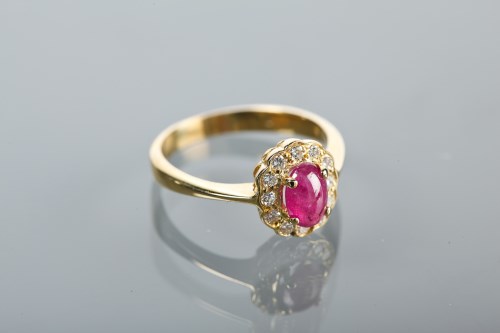 Lot 1115 - RUBY AND DIAMOND CLUSTER RING set with an oval...